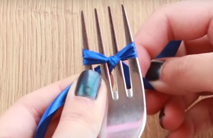 how to make dainty diy pearl bow earrings using a dinner fork, Tying a knot on a fork