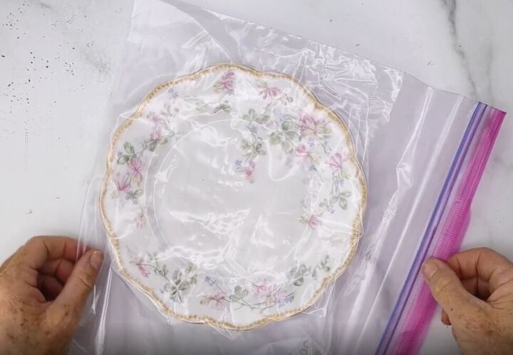 smash old china with a hammer to make pretty broken plate jewelry, Placing a porcelain plate into a Ziploc bag