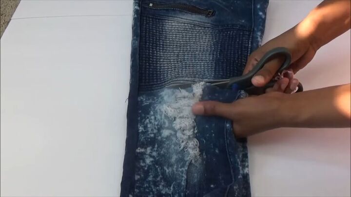 how to quickly turn your old distressed jeans into a stylish skirt, Cutting the bottom half of jean legs