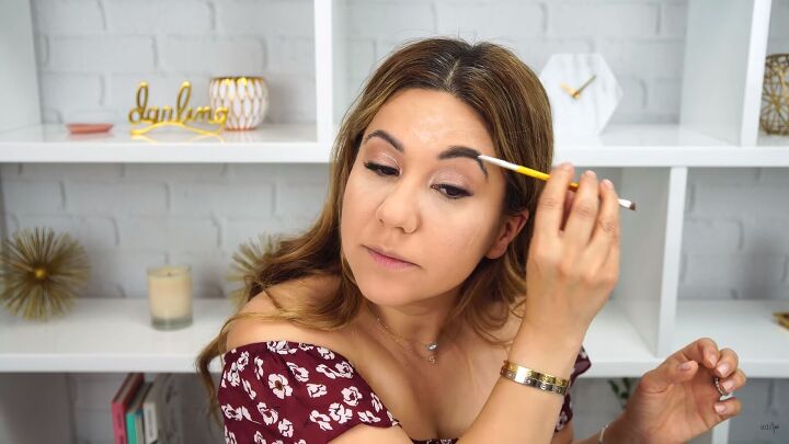 how to do simple everyday makeup you can take from day to night, Brushing eyebrow hairs with a spoolie