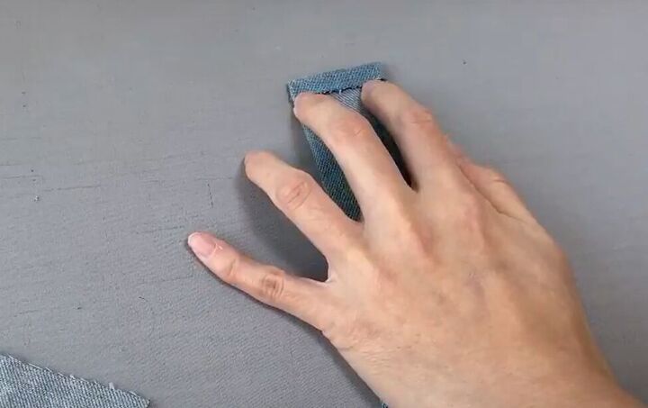 how to make a cute diy denim clutch bag out of an old jean dress, Folding and pressing the edges