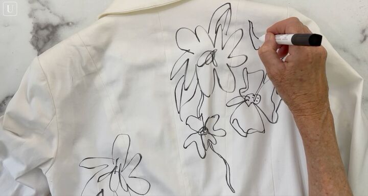 how to paint on fabric and create a one of a kind jacket, Drawing the floral design on a white jacket with black paint marker