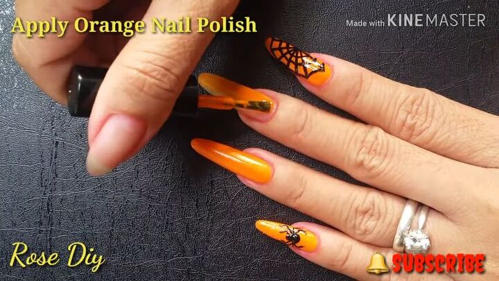 how to do fun spider web nail designs for halloween, Applying orange nail polish to Halloween nails