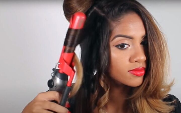 how to create a sophisticated masquerade hairstyle for halloween, Curling hair with a curling iron