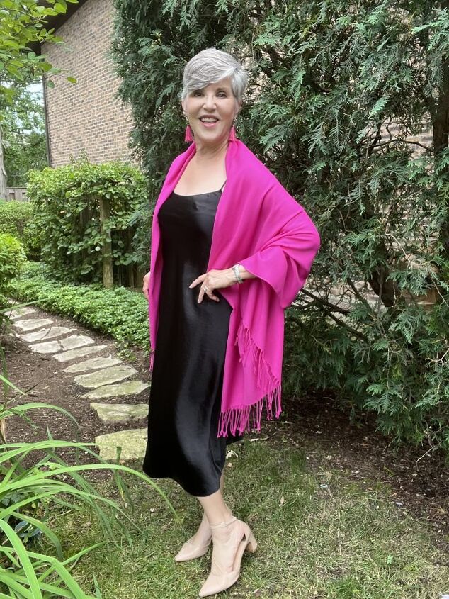 how to wear a slip dress seven different ways, I am wearing a black slip dress with a pink pashmina wrap and pink fringed earrings My shoes are nude pumps