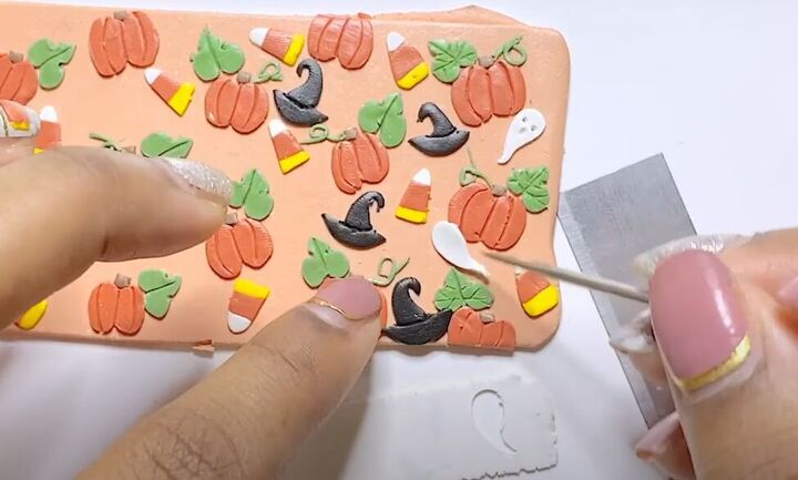adorable polymer clay pumpkin earrings tutorial, Adding Halloween ghosts to design