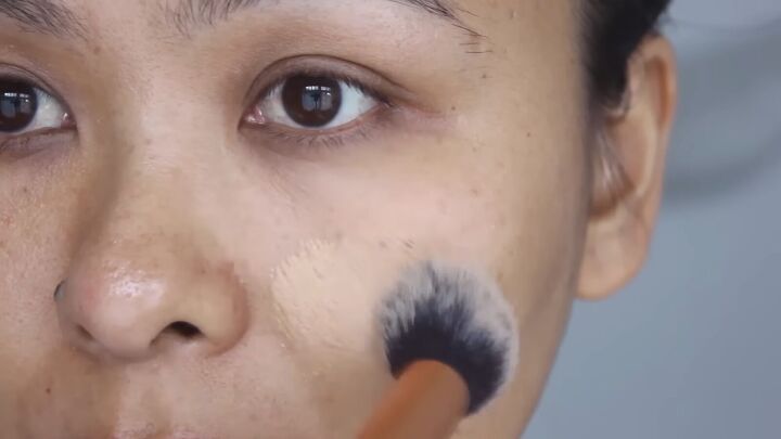 easy hacks on how to make pores disappear with makeup and skincare, Applying foundation with rounded fluffy brush
