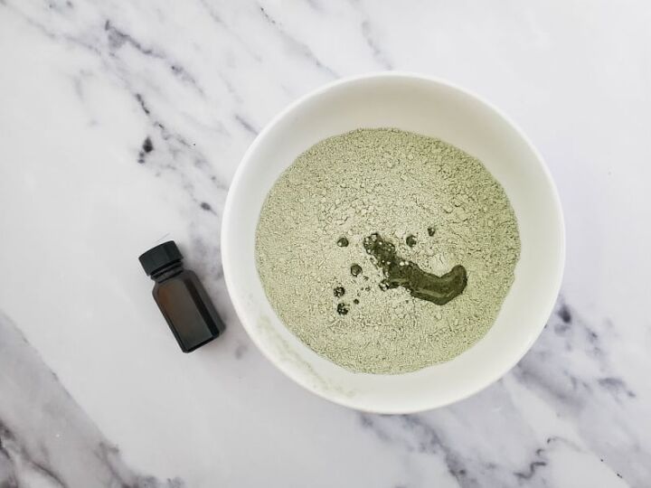 french green clay bath detox, an essential oil bottle near a bowl of green powder