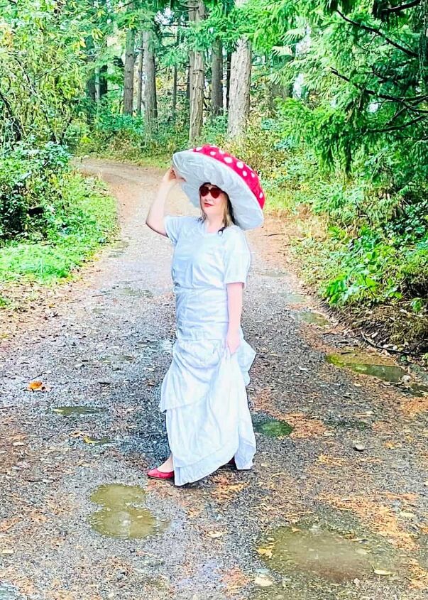 Woman dressed as a mushroom wearing red glasses in front of some trees