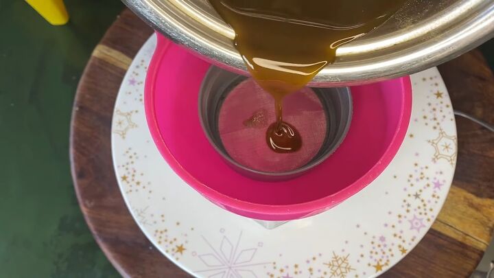 get long shiny hair with this super easy hair oil recipe, Pouring mixture into a jar