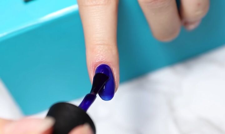 how to diy confetti nails for new year s eve, Applying blue nail polish