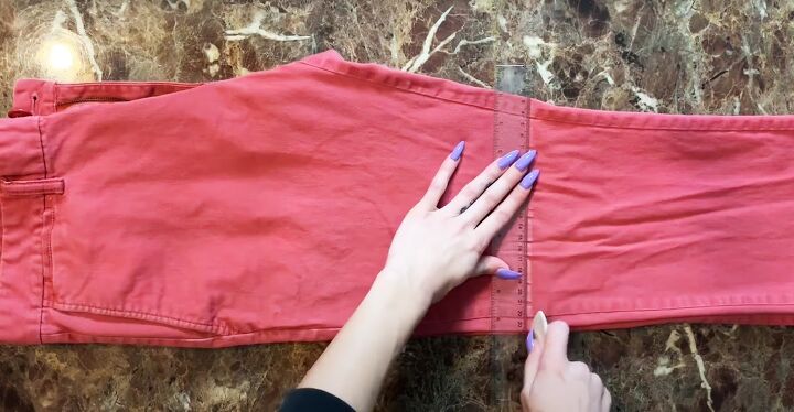 how to diy a cute button front skirt from oversized jeans, Cutting off legs