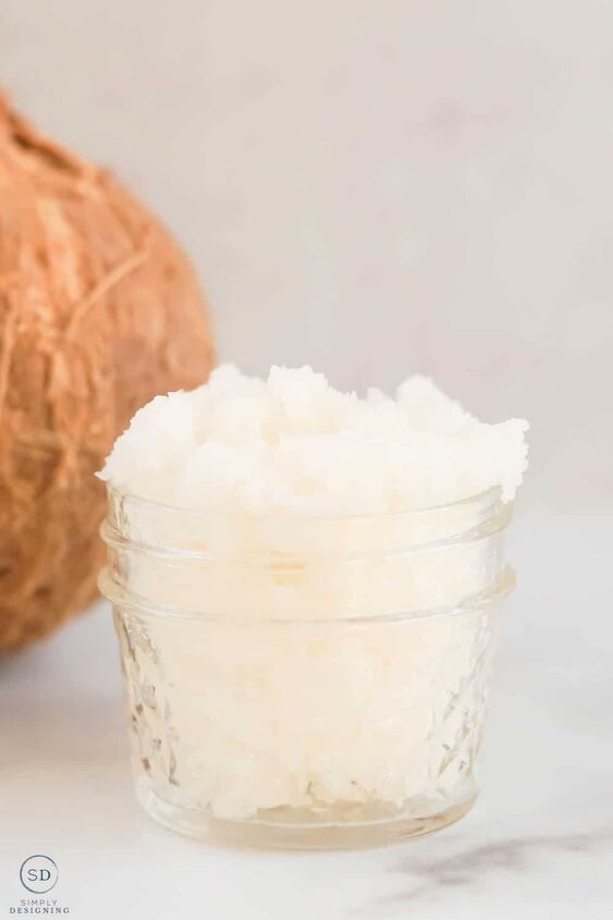peppermint sugar scrub, vertical photo of coconut body scrub in a small glass mason jar with a partial view of a coconut in the background