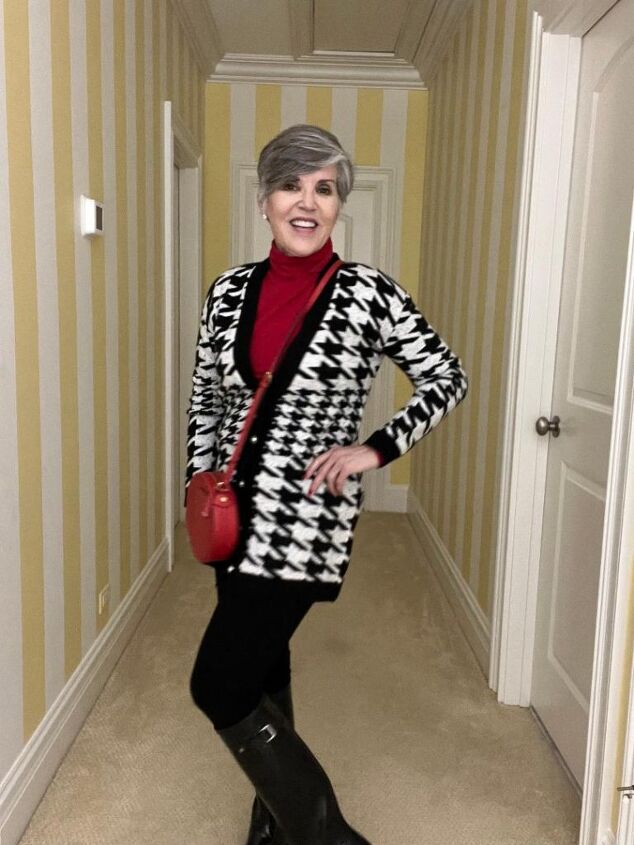 what i wore to nyc in december, I am wearing a black and white houndstooth cardigan over a red turtleneck with black leggings black boots and a red crossbody bag