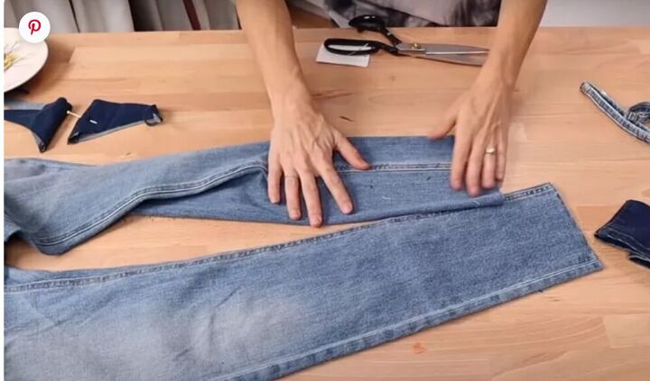 how to fray the bottom of jeans in 7 easy steps, Photo from The DIY Designer Laying jeans flat