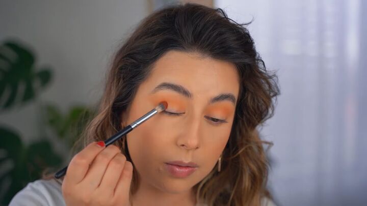 how to create a glam orange eye makeup look, Applying orange eyeshadow