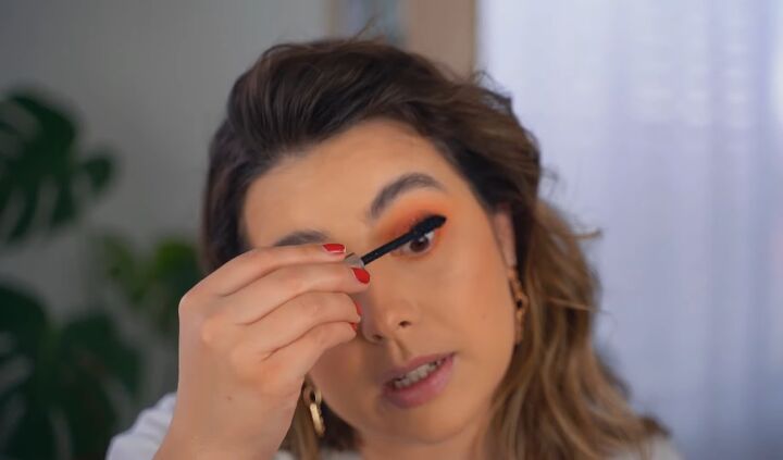 how to create a glam orange eye makeup look, Applying mascara