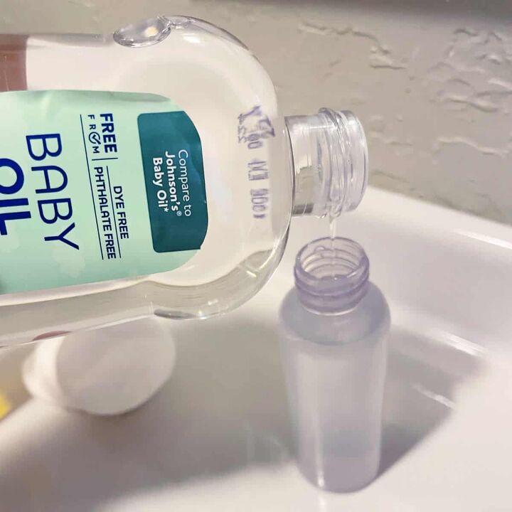 how to make your own eye makeup remover, Pouring baby oil into a small plastic bottle