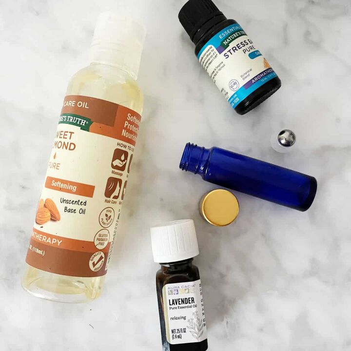 Supplies to make diy perfume oil on a marble counter