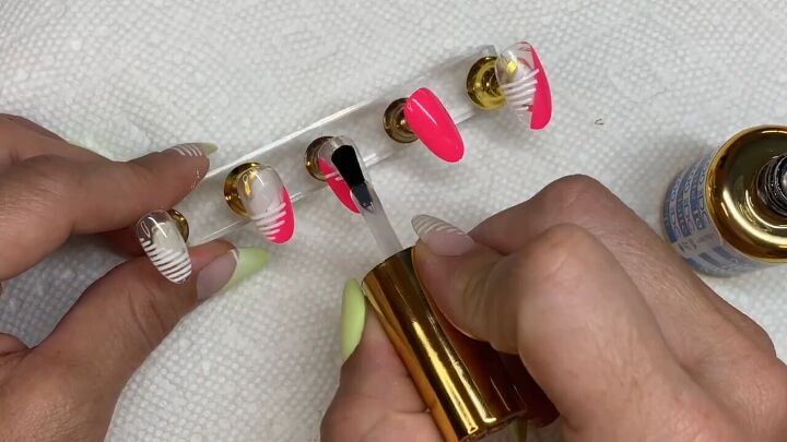 how to diy cute neon pink nails with a fun striped design, Applying top coat