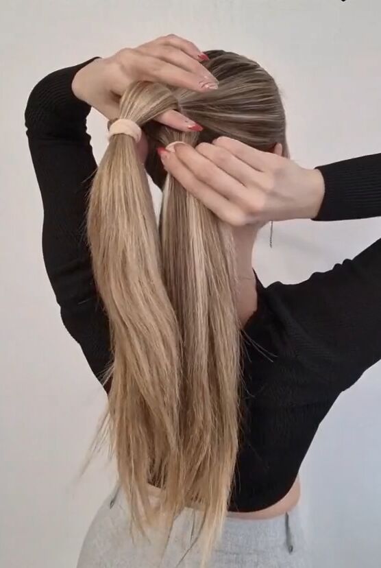try this hack instead of braiding your ponytail, Pulling one tail through the other