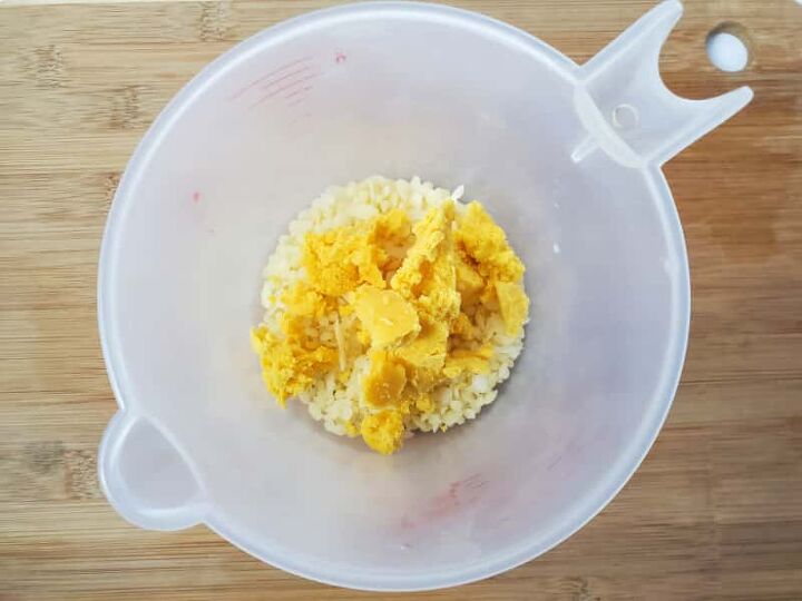 dandelion lotion bar diy, a measuring cup with ingredients to make this lotion bar