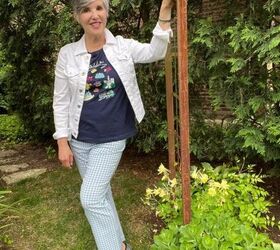 4 fun ways to style blue gingham pants for women, In this photo I am standing under a bronze arbor while wearing a navy blue vintage tee a white jean jacket and blue gingham pants My shoes are silver loafers