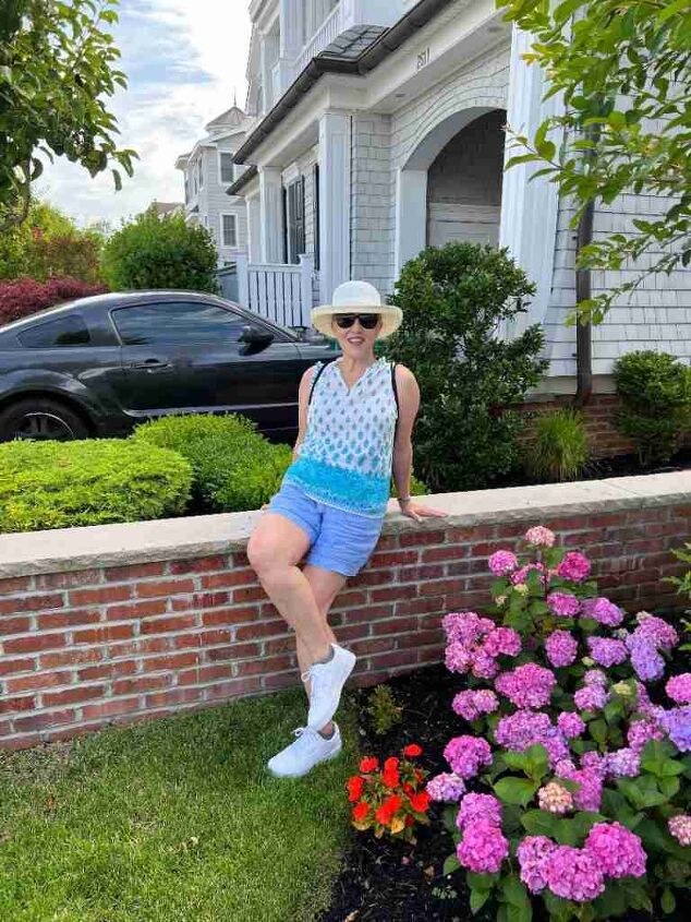 casual mom outfits, Here I a wearing a sleeveless foulard cotton tank in blue tones with blue linen shorts and white sneakers My hat is broad brimmed and my sunglasses are ovrtsized
