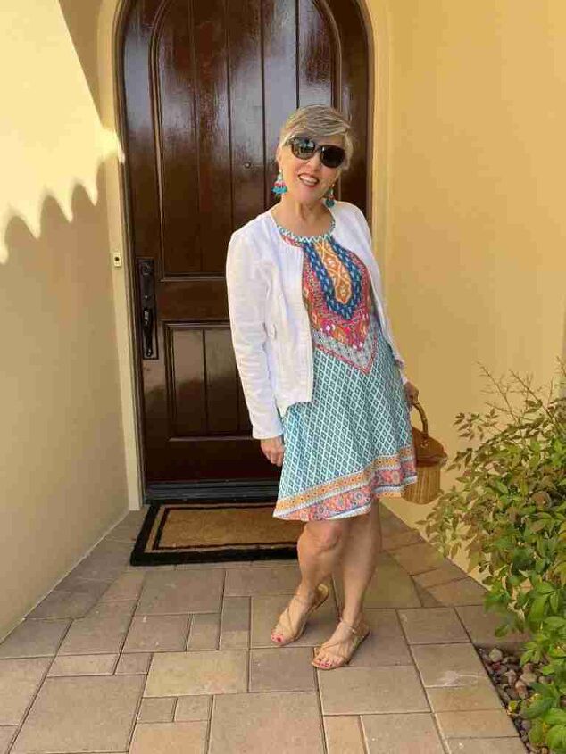 casual mom outfits, I am wearing the tenth of the casual mom outfits I am wearing a darling sleeveless blue yellow and red foulard pattern dress with a central design I added a white cotton cardigan fun earrings nude sandals and oversized sunglasses