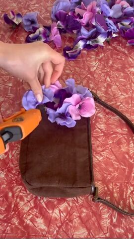 grab some dollar tree flowers to upcycle a purse, Gluing flowers to purse