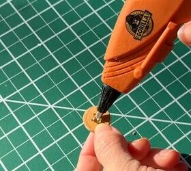She dabs hot glue on a button for this totally clever idea