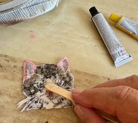 She puts glue on a popsicle stick to give these embroidered patches an adorable upgrade