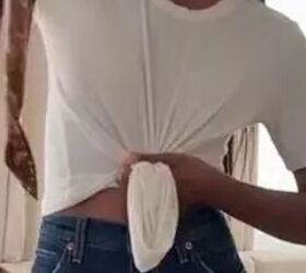 She grabs the center of her shirt before getting dressed